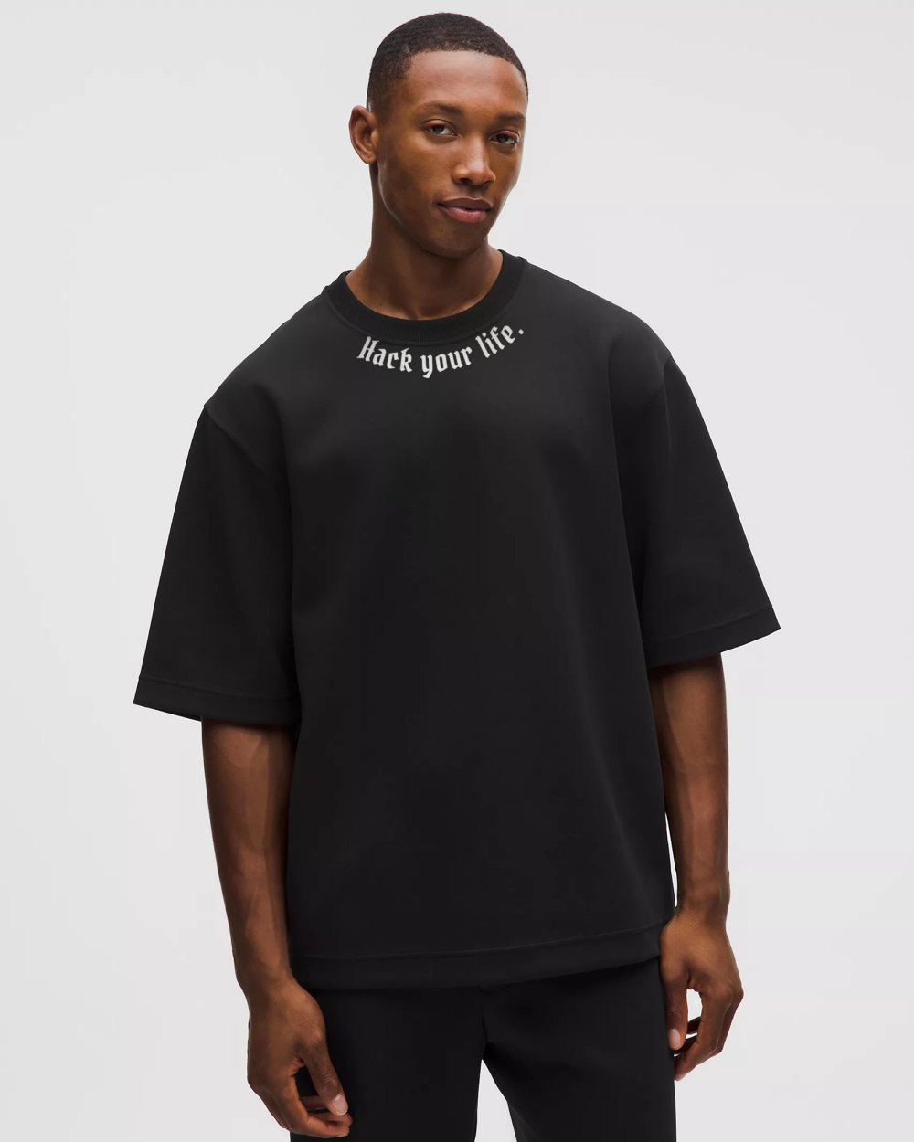 Black oversized tee with Hack your life printed around the collar