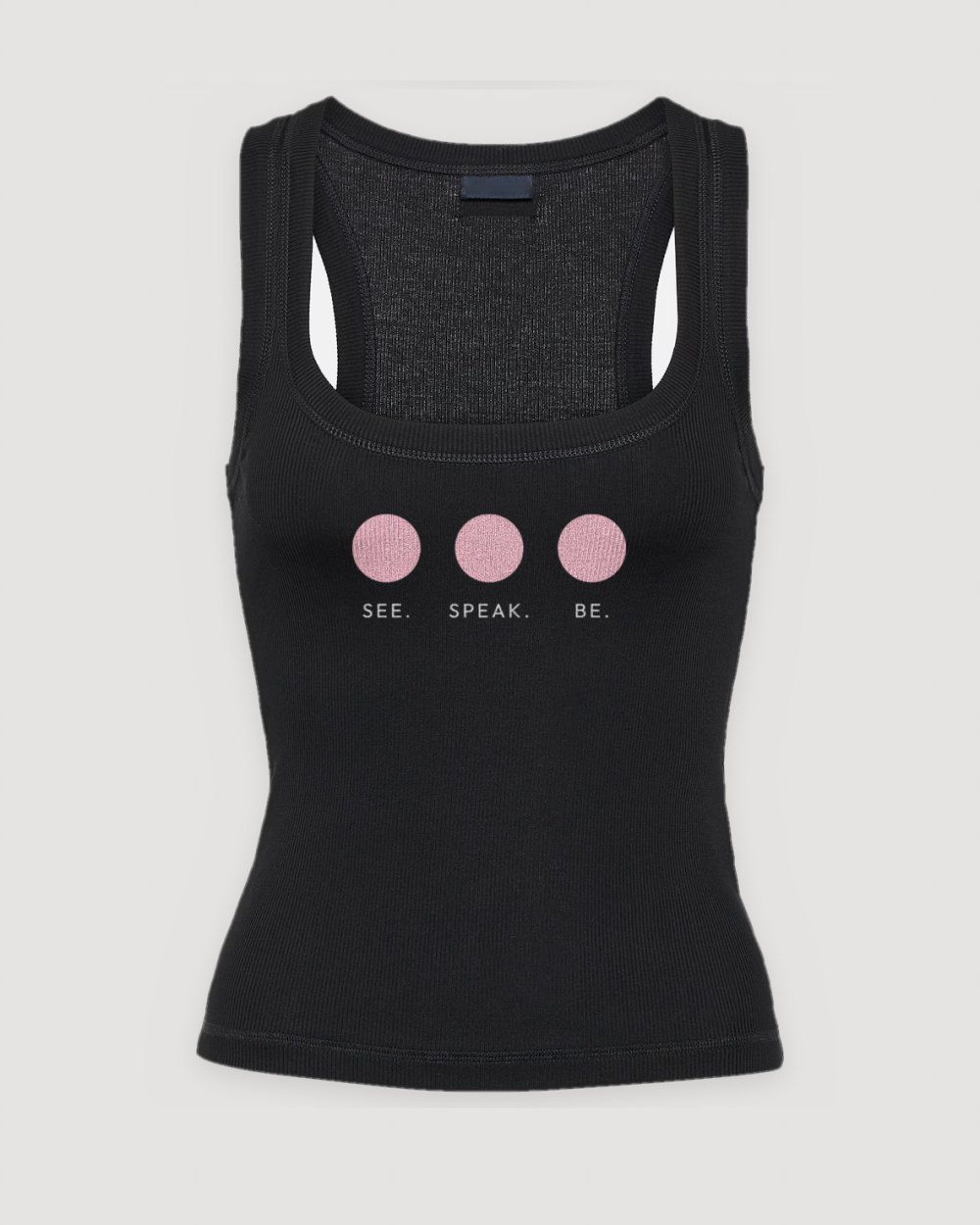 Black ribbed tank with three pink dots in a row over See. Speak. Be.